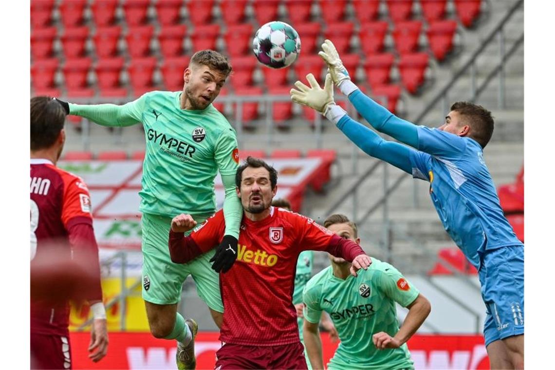 Kieler Pokalhelden straucheln - Bochum und Fortuna drücken Regensburg-Torwart Alexander Meyer (r) kommt vor dem einköpfbereiten Sandhausener Alexander Esswein (l) an den Ball. Foto: Armin Weigel/dpa