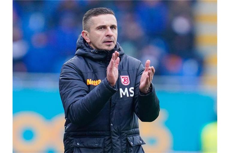 Regensburgs Trainer Mersad Selimbegovic applaudiert. Foto: Uwe Anspach/dpa/Archivbild