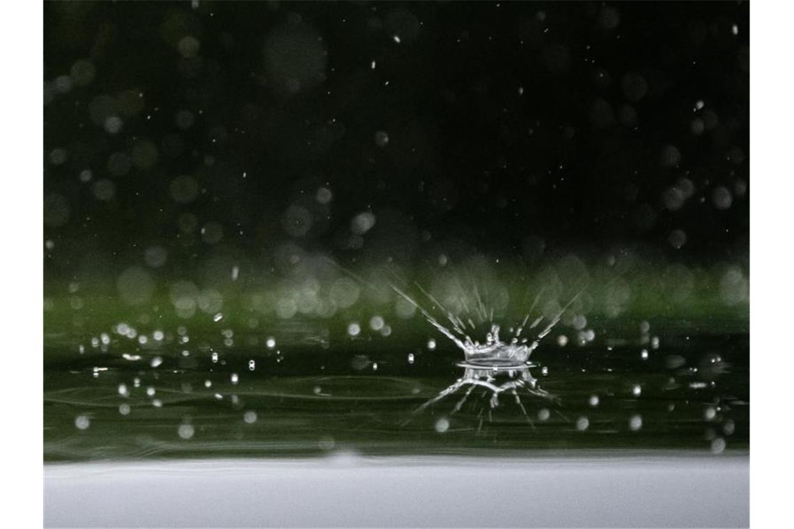 Regentropfen fallen auf ein Autodach. Foto: Sebastian Gollnow/dpa/Archivbild