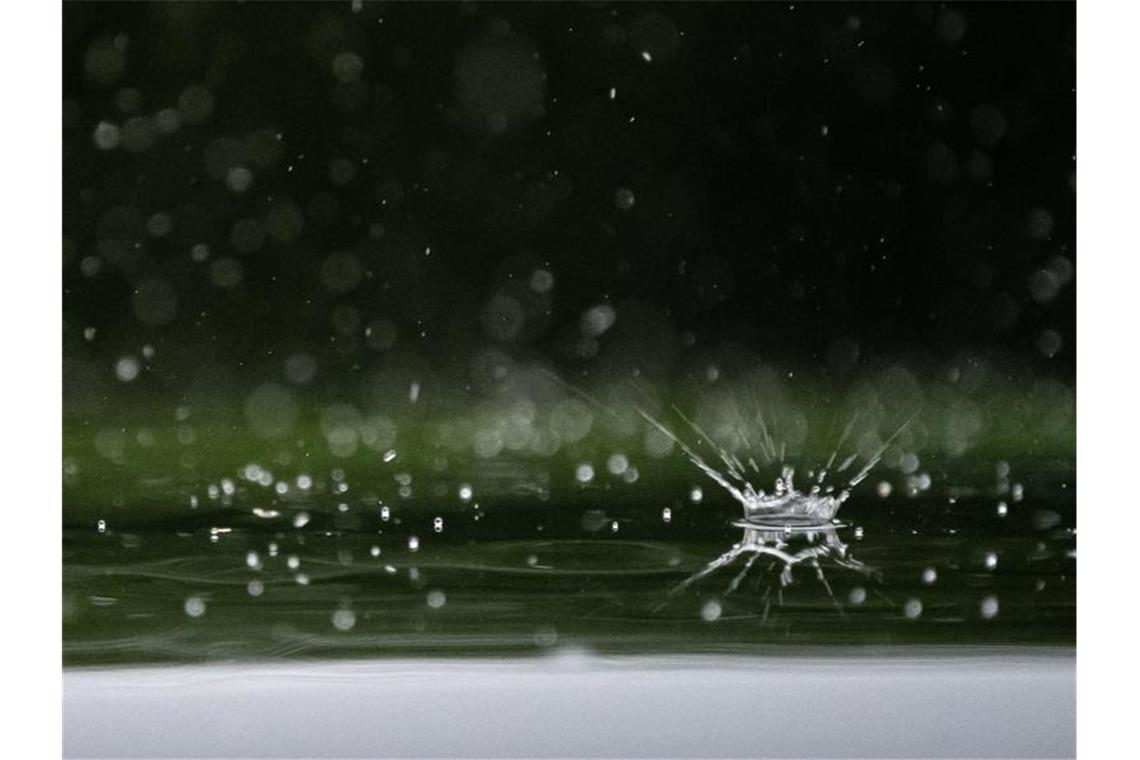 Regentropfen fallen auf ein Autodach. Foto: Sebastian Gollnow/dpa/Archivbild