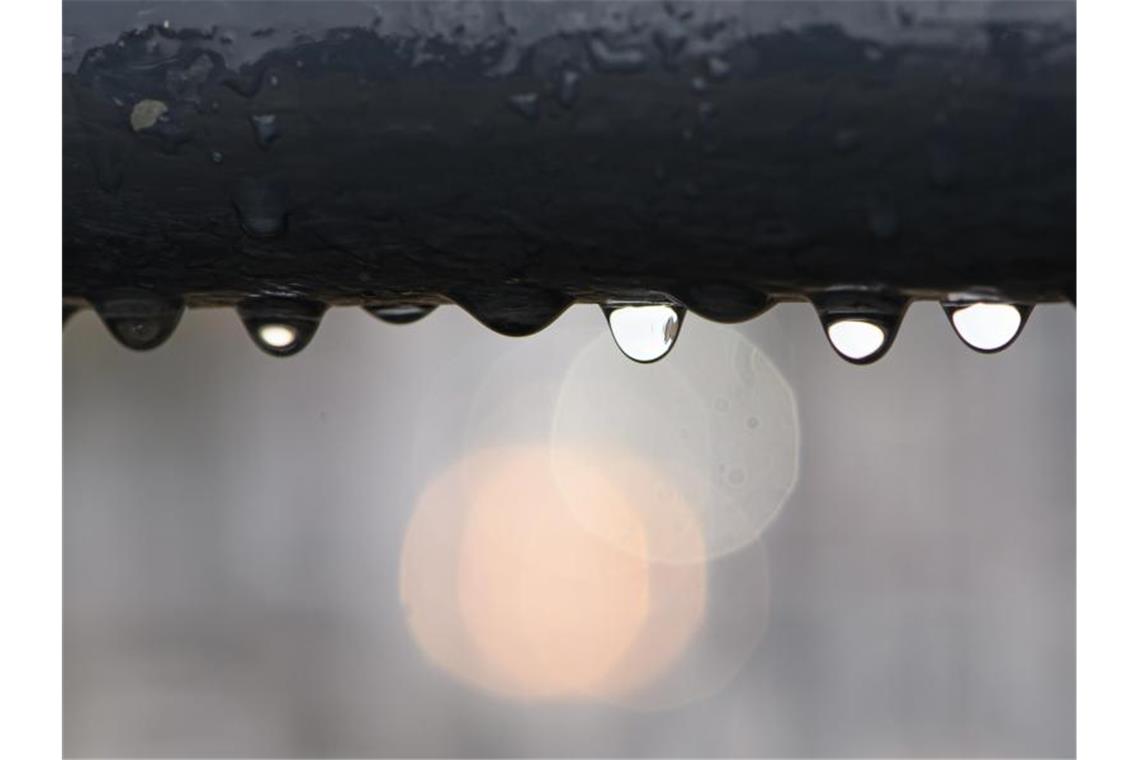 Grau und viel Regen: Wetter im Südwesten wird wechselhaft Regentropfen hängen an einem Geländer. Foto: Robert Michael/dpa-Zentralbild/dpa/Symbolbild