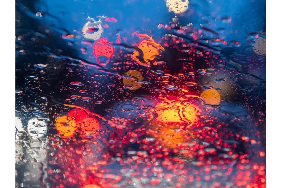 Regentropfen sind am Morgen im Berufsverkehr auf einer Autoscheibe zu sehen. Foto: Robert Michael/dpa-Zentralbild/ZB/Archivbild
