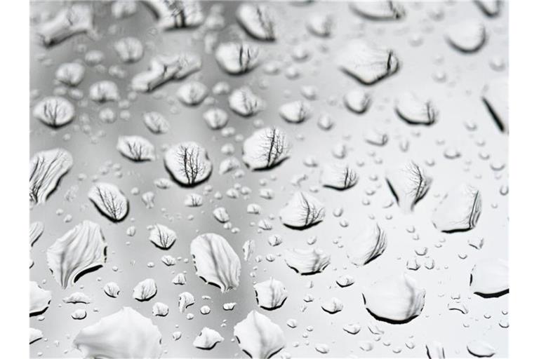 Regentropfen sind auf einer Fensterscheibe zu sehen. Foto: Mohssen Assanimoghaddam/dpa/Symbolbild