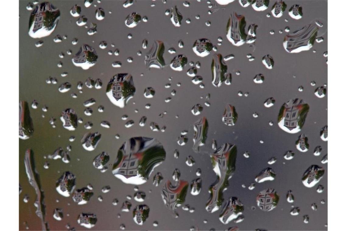 Regentropfen sind auf einer Fensterscheibe zu sehen. Foto: Hendrik Schmidt/dpa-Zentralbild/ZB/Symbolbild