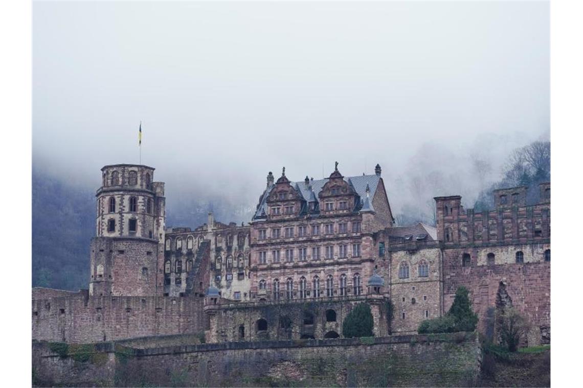 Regenwolken hängen über dem Heidelberger Schloss. Foto: Uwe Anspach/dpa/Archivbild