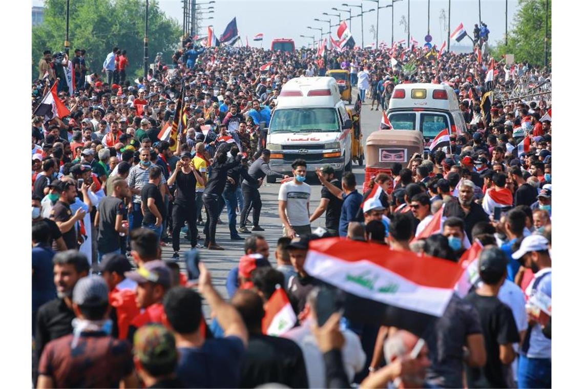 Regierungsfeindliche Demonstranten protestieren auf einer Straße in Bagdad. Die Proteste vor allem junger Männer richten sich gegen Korruption und Misswirtschaft. Foto: Ameer Al Mohammedaw/dpa