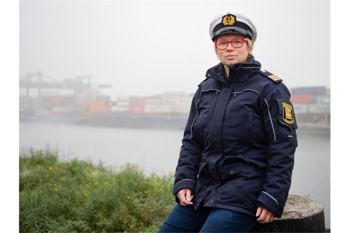 Regina Güntert, Leiterin der Hafenmeisterei, sitzt an einem Containerhafen. Foto: Tom Weller/dpa