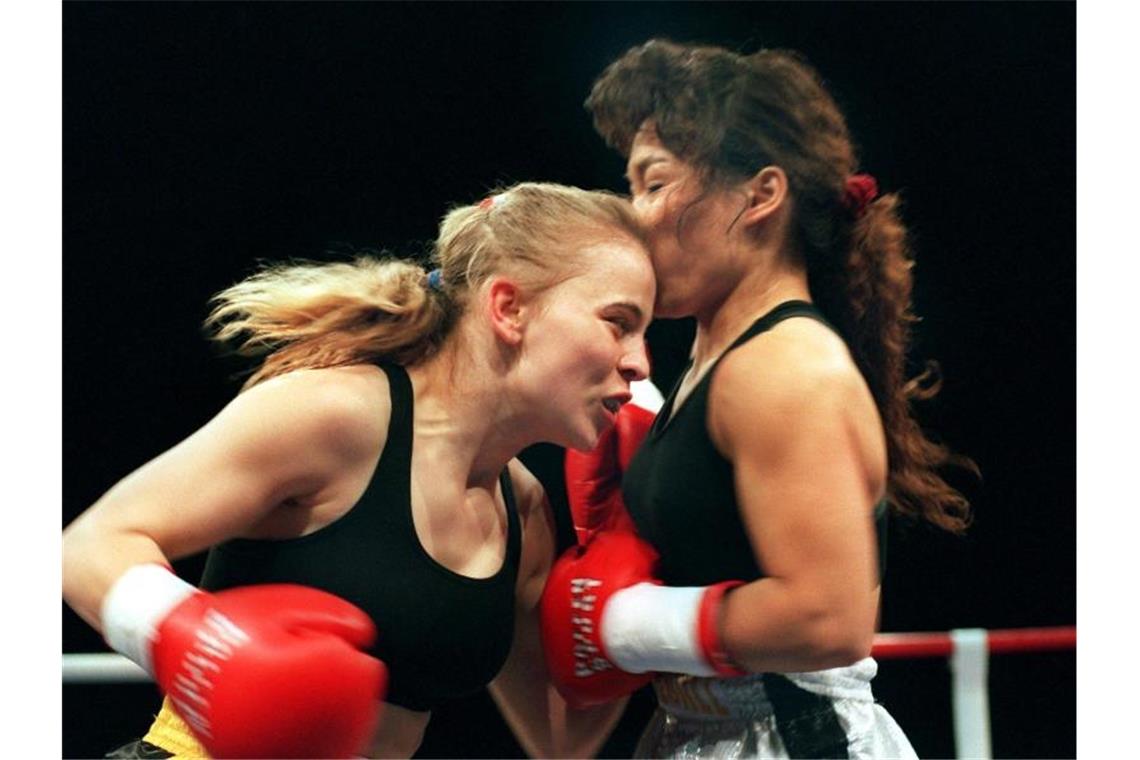 Regina Halmich (l.) und Kim Messer boxen im Ring. Foto: Uli Deck/dpa