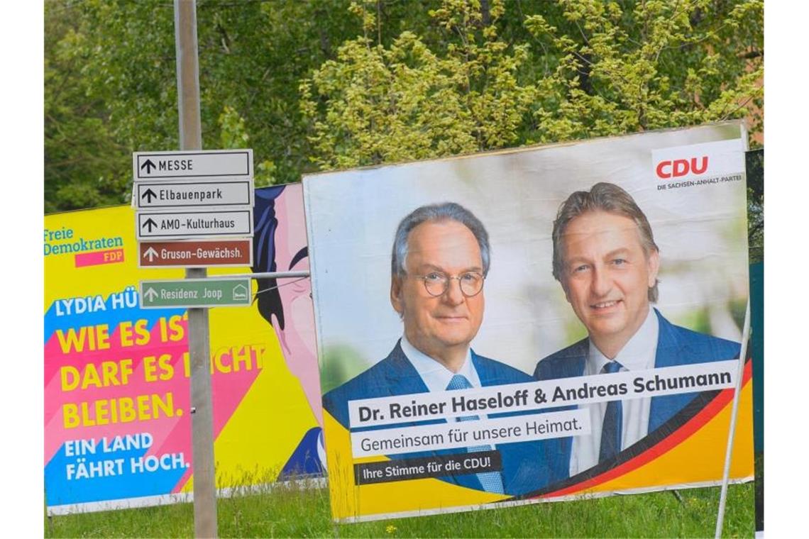 Reiner Haseloff (auf dem Plakat links) ist mit 67 im Rentenalter. Und im Karrierehoch. Foto: Klaus-Dietmar Gabbert/dpa-Zentralbild/dpa