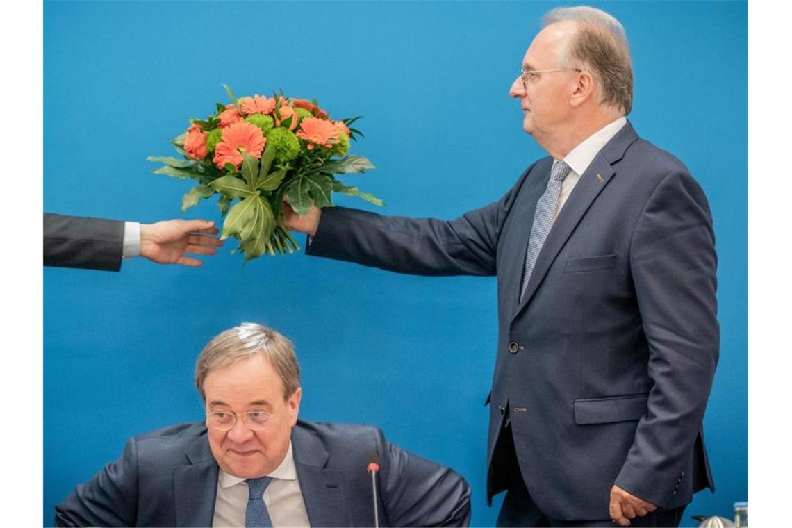 Haseloff will stabiles Regierungsbündnis nach CDU-Wahlsieg Reiner Haseloff (r.) übergibt einen Blumenstrauß, den er Armin Laschet erhalten hat. Foto: Michael Kappeler/dpa-pool/dpa