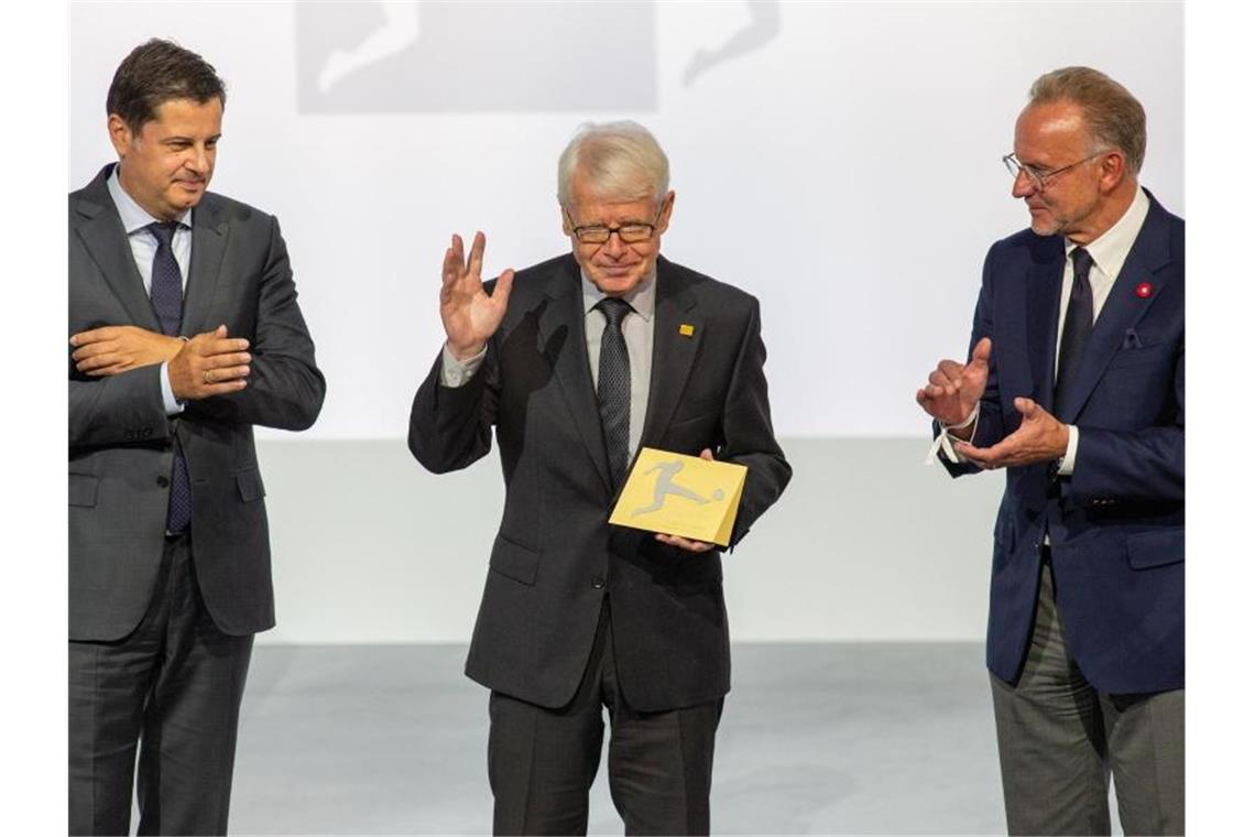 Reinhard Rauball (M) wird durch Christian Seifert (l) und Karl-Heinz Rummenigge verabschiedet. Foto: Andreas Gora