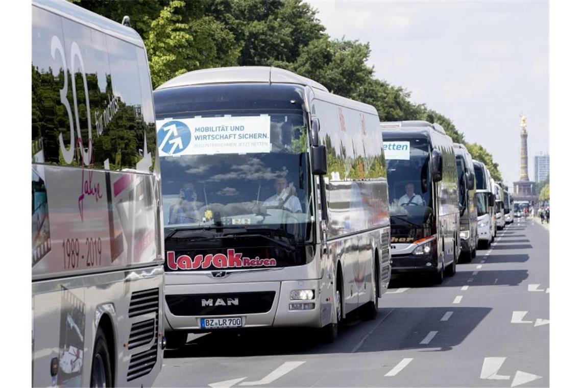 Reisebusse fahren bei einer Protestaktion zur wirtschaftlichen Lage von Bus- und Touristikunternehmen auf der Straße des 17. Juni vor der Siegessäule in Berin. Foto: Christoph Soeder/dpa