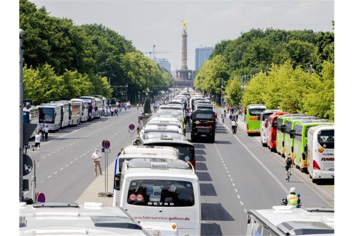 Reisebusse stehen bei einer Protestaktion zur wirtschaftlichen Lage von Bus- und Touristikunternehmen auf der Straße des 17. Juni vor der Siegessäule in Berlin. Foto: Christoph Soeder/dpa
