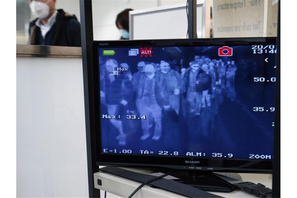 Chinesische Städte wegen Virus abgeriegelt Reisen verbreitet Viren: Passagiere aus dem chinesischen Wuhan und anderen Städten durchlaufen auf dem internationalen Flughafen Narita Bei Tokio Körpertemperatur-Scanner. Foto: Eugene Hoshiko/AP/dpa