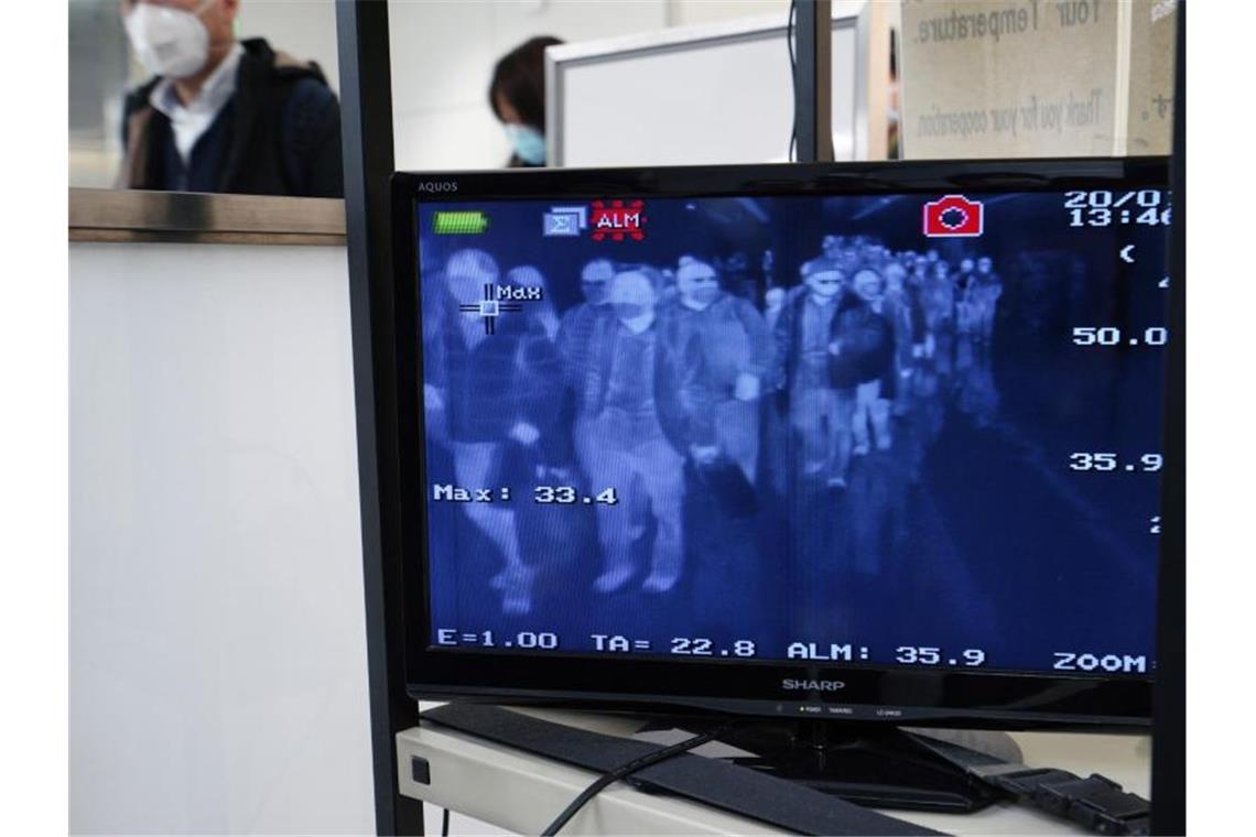 Reisen verbreitet Viren: Passagiere aus dem chinesischen Wuhan und anderen Städten durchlaufen auf dem internationalen Flughafen Narita Bei Tokio Körpertemperatur-Scanner. Foto: Eugene Hoshiko/AP/dpa