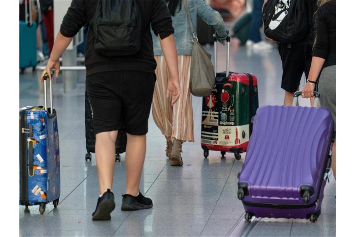 Stuttgarter Flughafen: Wenige Passagiere im ersten Halbjahr Reisende gehen mit Koffern durch die Abflughalle. Foto: Henning Kaiser/dpa/Archivbild