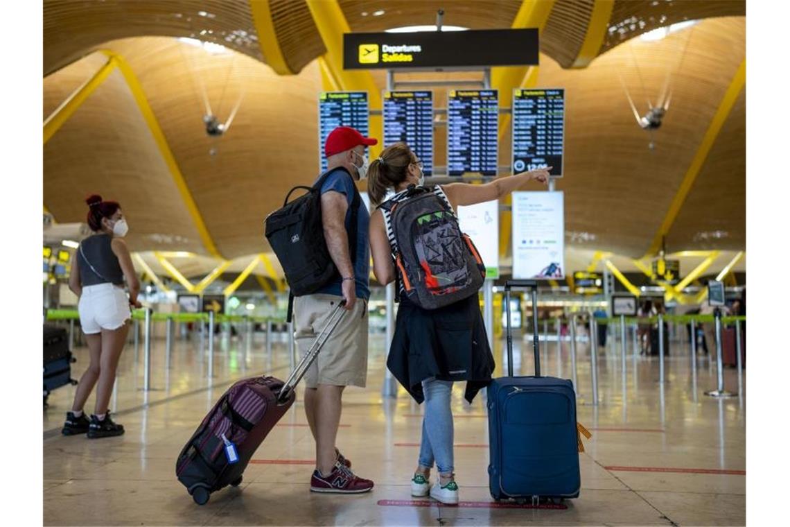 Reisende in einer Halle im Flughafen Madrid-Barajas. Foto: Manu Fernandez/AP/dpa
