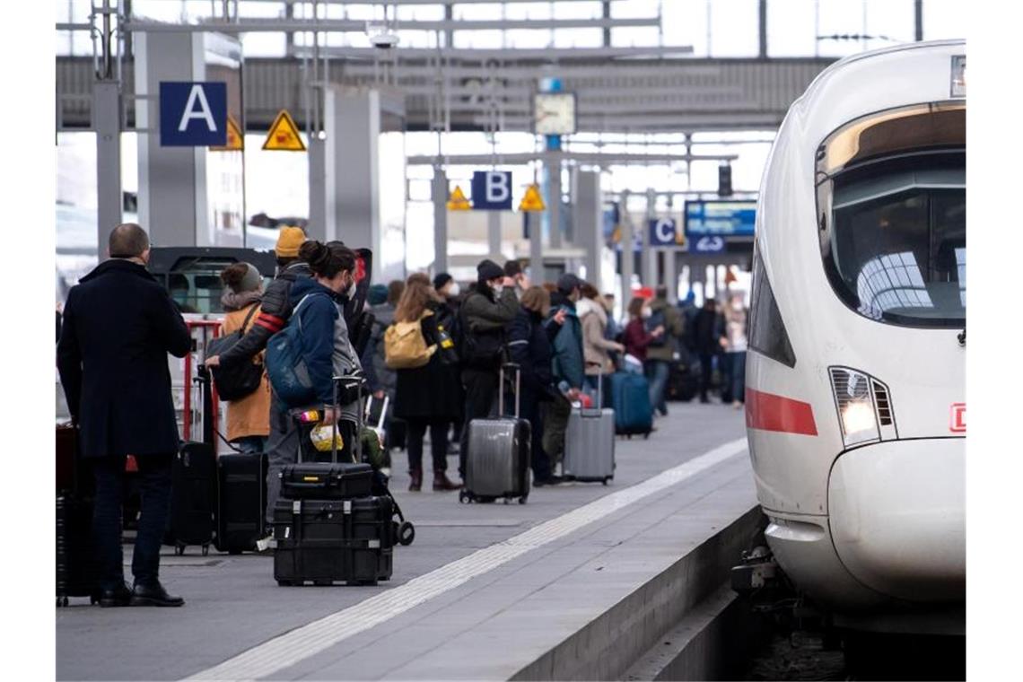 Reisende neben einem ICE am Münchener Hauptbahnhof. Foto: Sven Hoppe/dpa