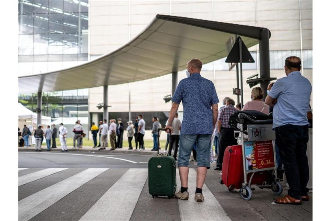 Reisende stehen am Corona-Testzentrum am Flughafen Köln/Bonn an. Foto: Marius Becker/dpa