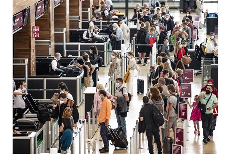 Reisende stehen am Flughafen am Security Check. Deutschland lockert die wegen der Verbreitung besonders ansteckender Corona-Varianten verhängten Einreisebeschränkungen unter anderem für Portugal und Großbritannien. Foto: Fabian Sommer/dpa