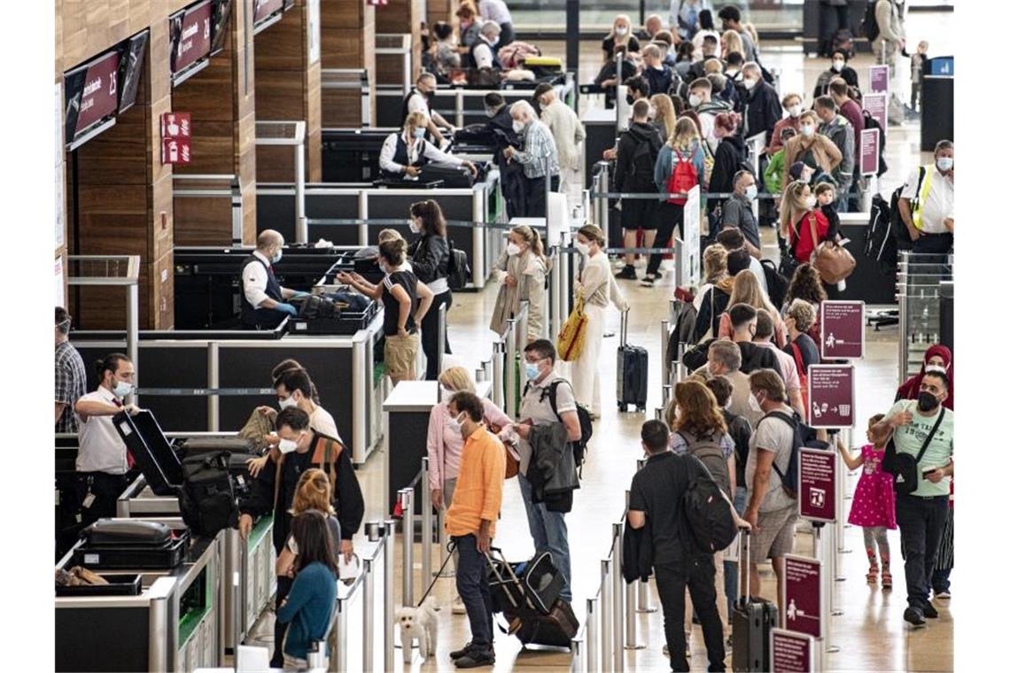 Reisende stehen am Flughafen BER am Security Check. Die Fluggastzahlen am BER haben in den vergangenen Monaten wieder deutlich zugenommen. Foto: Fabian Sommer/dpa