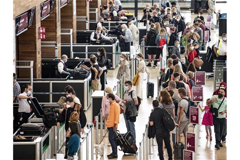 Reisende stehen am Flughafen BER am Security Check. Die Fluggastzahlen am BER haben in den vergangenen Monaten wieder deutlich zugenommen. Foto: Fabian Sommer/dpa
