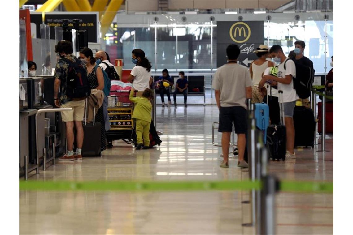 Reisende stehen an den Check-in-Schaltern im Terminal T1 des Flughafens in Madrid. Foto: Óscar Cañas/EUROPA PRESS/dpa