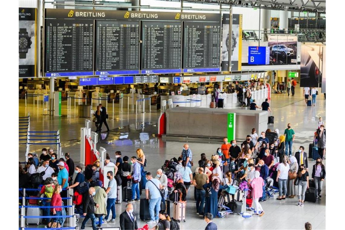 Reisende stehen in der Abflughalle im Terminal 1 am Flughafen Frankfurt. Hier herrscht noch immer deutlich weniger Betrieb als in Vor-Corona-Zeiten. Foto: Andreas Arnold/dpa