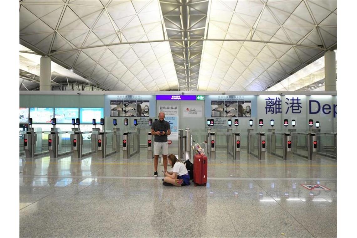 Heftige Zusammenstöße in Hongkongs Flughafen Reisende warten nach der ersten Sperrung am Montag im Terminal des Flughafens. Foto: Lui Siu Wai/XinHua