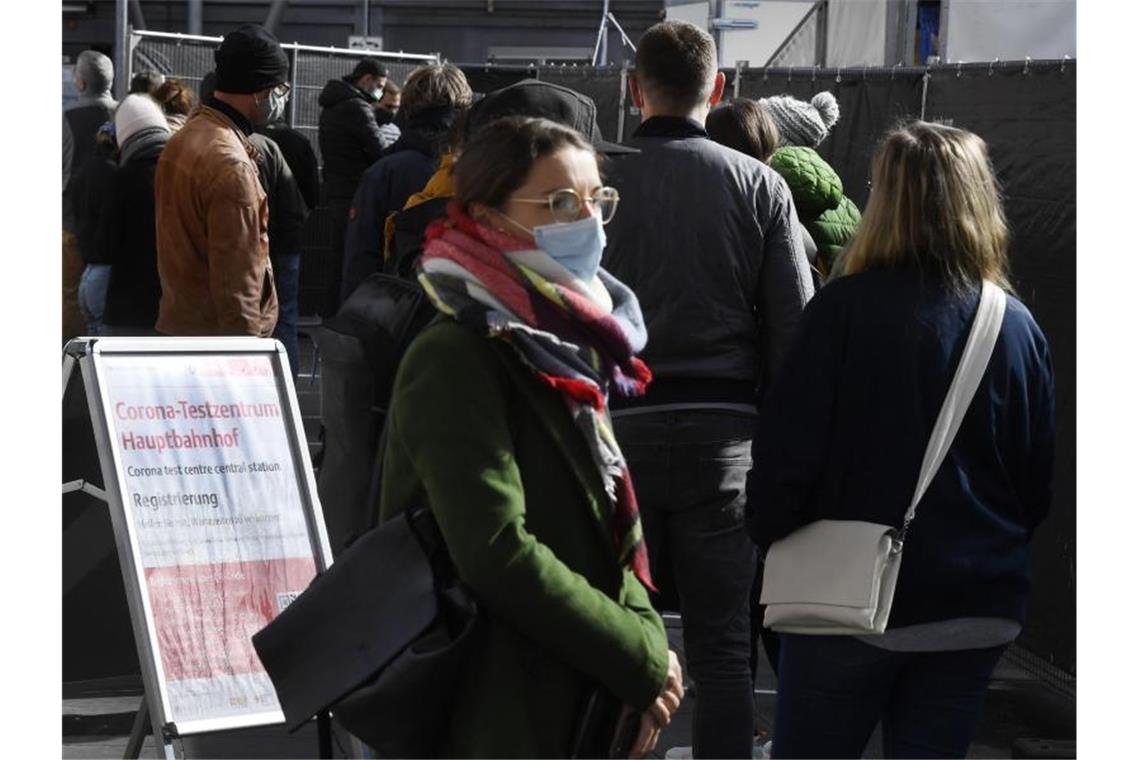 Reisende warten vor dem Corona-Testzentrum am Kölner Hauptbahnhof. Foto: Roberto Pfeil/dpa