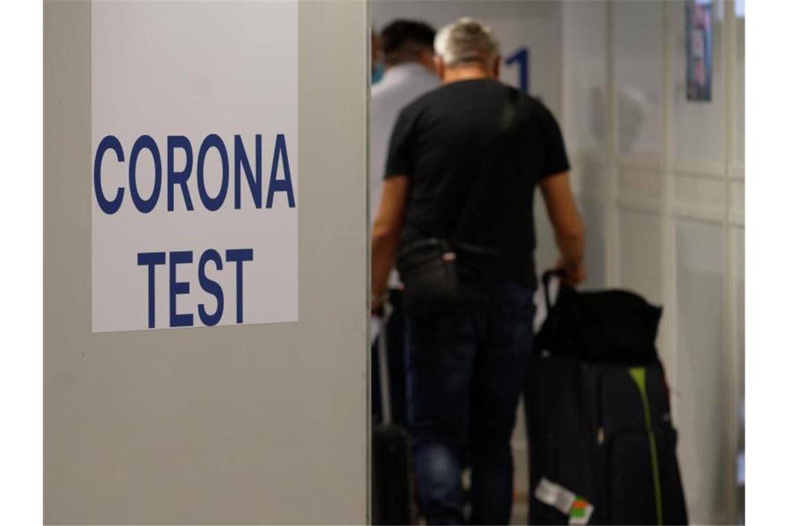 Reiserückkehrer gehen im Flughafen Düsseldorf zum Corona-Testzentrum. Foto: Henning Kaiser/dpa