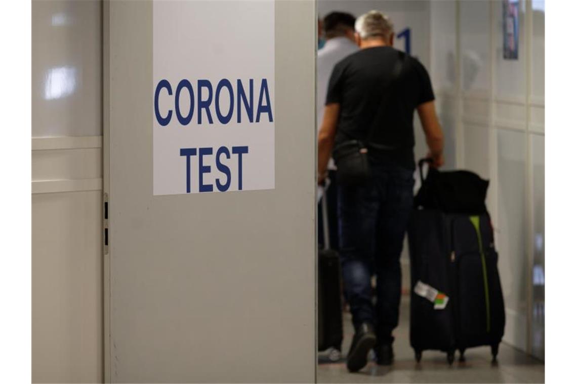 Reiserückkehrer gehen zum Corona-Testzentrum im Flughafen Düsseldorf. Foto: Henning Kaiser/dpa