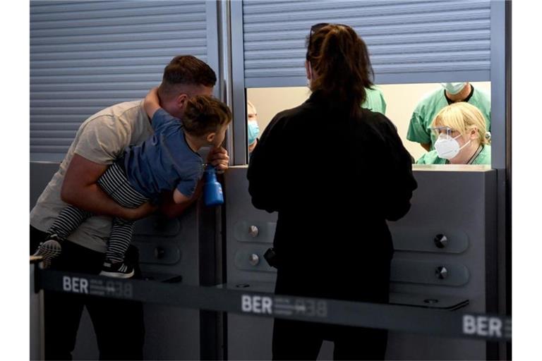 Reiserückkehrer stehen am Flughafen Tegel am Corona-Teststand. Foto: Britta Pedersen/dpa-Zentralbild/dpa