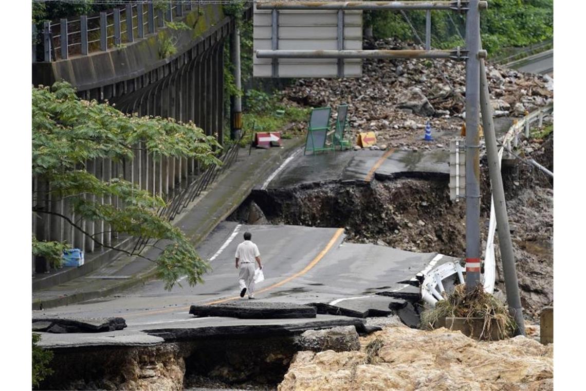 Rekordstarke Regenfälle hatten am Wochenende schwere Überflutungen und Erdrutsche im Südwesten Japans ausgelöst und hohe Schäden verursacht. Hier eine völlig zerstörte Straße nahe Kumamura. Foto: Koji Harada/Kyodo News/AP/dpa