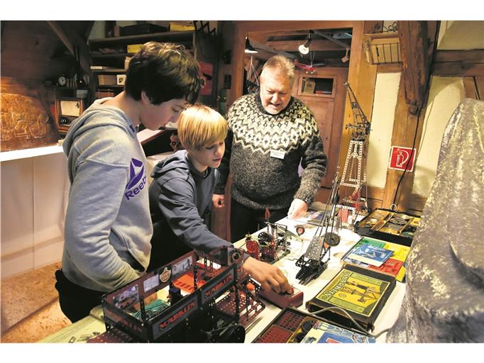 Reminiszenz an die eigene Kindheit und Jugend: Ben (links, 13 Jahre) und Benni (14 Jahre) sind begeistert von den Metallbaukästen, mit denen ihre Eltern und Großeltern spielten. Sie testen den Märklin-Drehzahlmesser. Jochen Elzmann, Vorsitzender des Historischen Vereins Burgstetten, erklärt den beiden Ausstellungsbesuchern das Metallspielzeug. Foto: T. Sellmaier