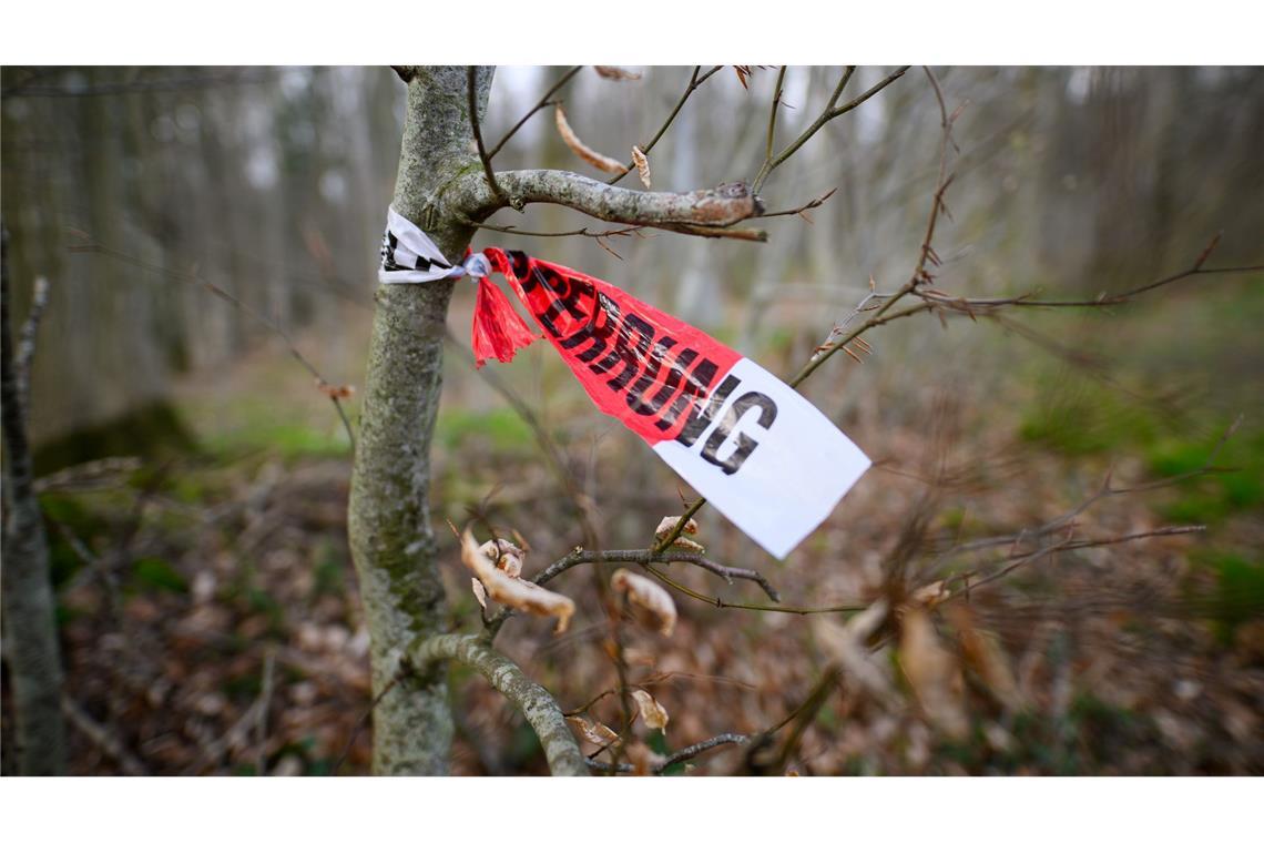 Reste einer Polizeiabsperrung sind in dem betroffenen Waldstück zu sehen.