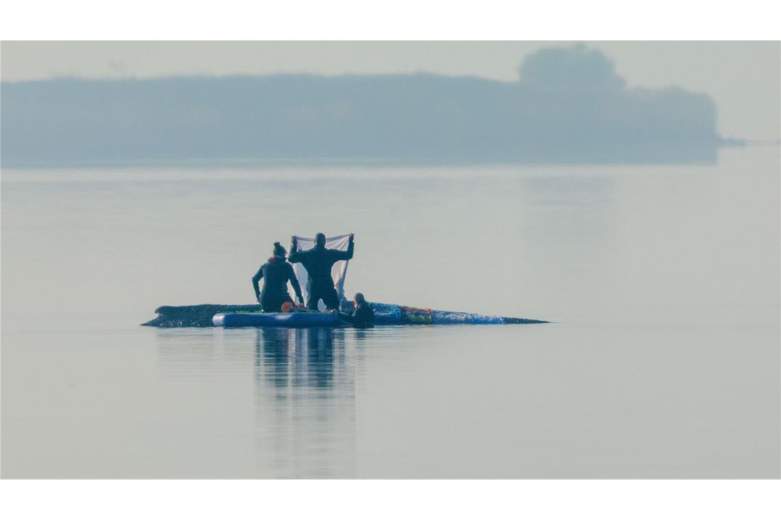Retter sind am Morgen in der Nähe des Buckelwal vor der Insel Poel und legen Tücher auf dem Walrücken aus.