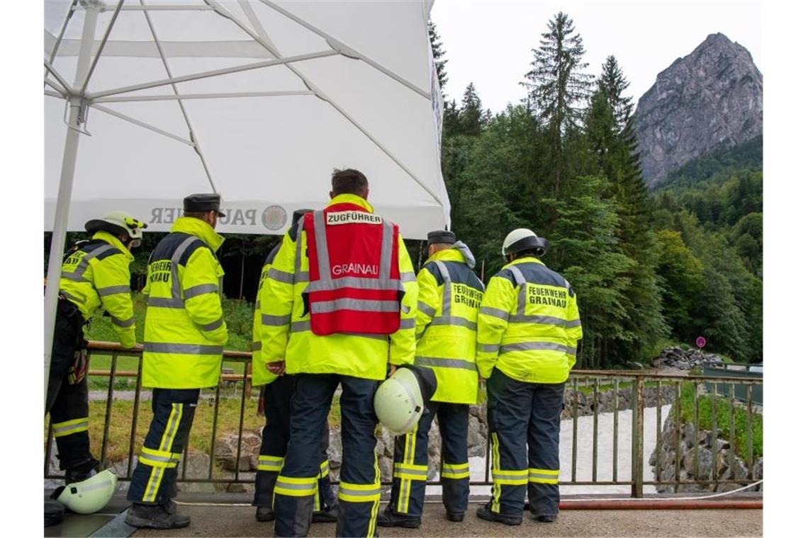 Retter stehen nach der Flutwelle in der Höllentalklamm bereit, um im Notfall Opfer aus dem Fluss Hammersbach zu bergen. Foto: Peter Kneffel/dpa