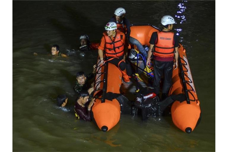 Retter suchen nach Opfern, die in einem Fluss in Ciamis ertrunken sind. Foto: Yopi Andrias/AP/dpa