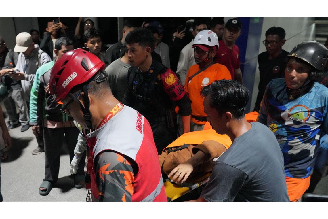 Retter tragen eine Frau auf einer Trage.