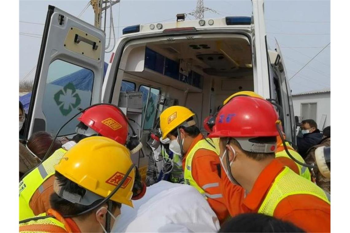 Retter tragen einen Bergarbeiter zu einem Krankenwagen. Zwei Wochen nach einem Grubenunglück im Osten Chinas wurde er geborgen. Foto: Luan Qincheng/XinHua/dpa