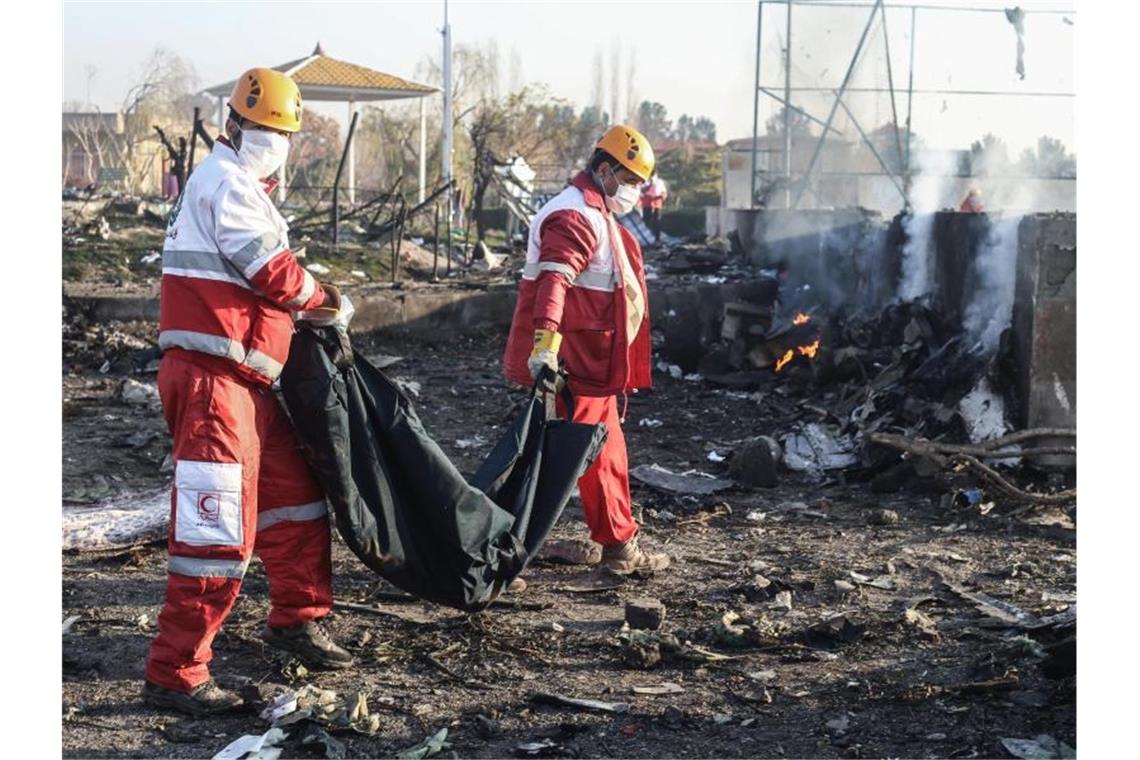 Rettungskräfte an der Absturzstelle bei Teheran. Foto: Mahmoud Hosseini/dpa