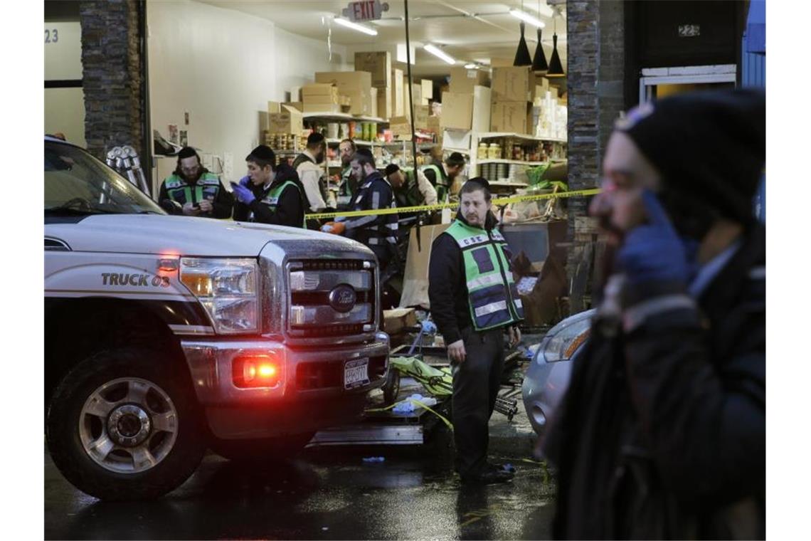 Rettungskräfte arbeiten in dem koscheren Supermarkt, wo bei einem stundenlangen Schusswechsel sechs Menschen starben. Foto: Seth Wenig/AP/dpa