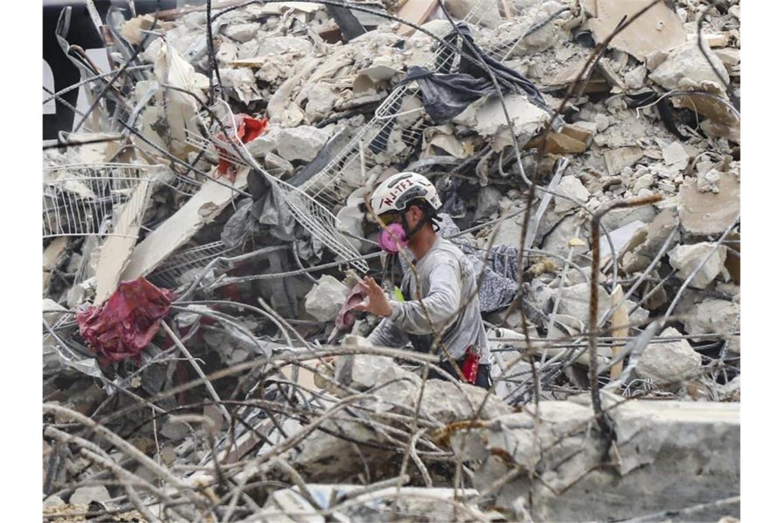 Rettungskräfte arbeiten sich durch die Trümmern des teilweise eingestürzten Wohnkomplexes. Foto: Al Diaz/Miami Herald/AP/dpa