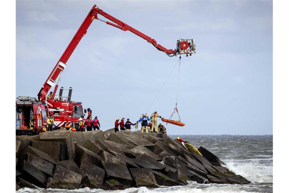 Rettungskräfte bergen eine Leiche, die sie bei der erneuten Suche nach den vermissten Wassersportlern im Noordelijk Havenhoofd gefunden haben. Foto: "sem Van Der Wal"/ANP/dpa