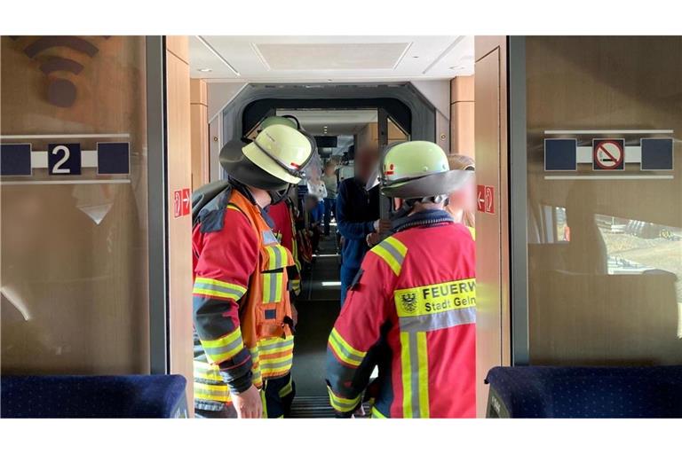 Rettungskräfte der Feuerwehr stehen im ICE.