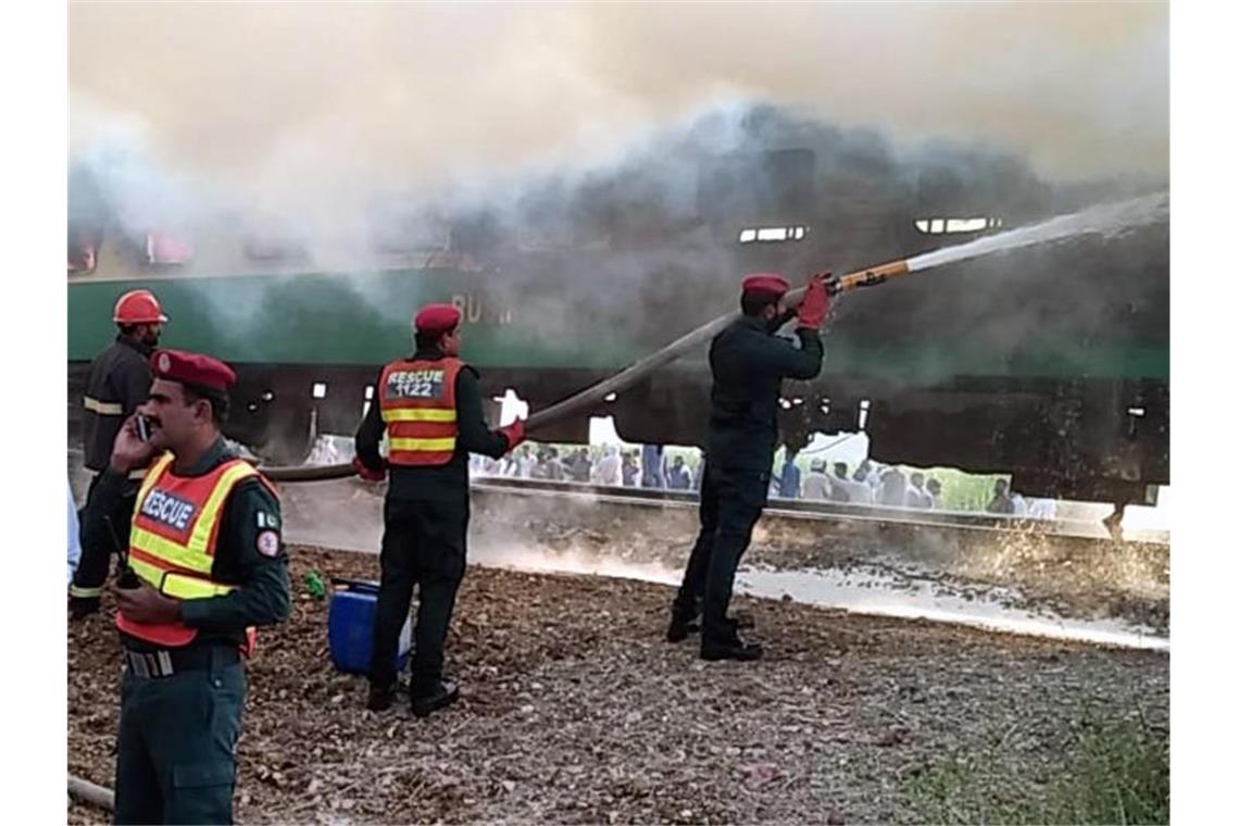Mehr als 70 Tote bei Feuer-Inferno in pakistanischem Zug Rettungskräfte der Feuerwehr versuchen, das Feuer des Personenzuges zu löschen. Foto: Str/XinHua/dpa