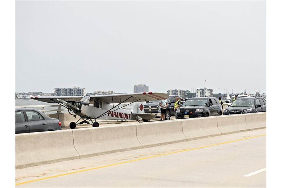 Kleinflugzeug landet auf Schnellstraße not Rettungskräfte im Gespräch mit dem Piloten, der notgelandet ist. Foto: Matthew Strabuk/The Press of Atlantic City/AP/dpa