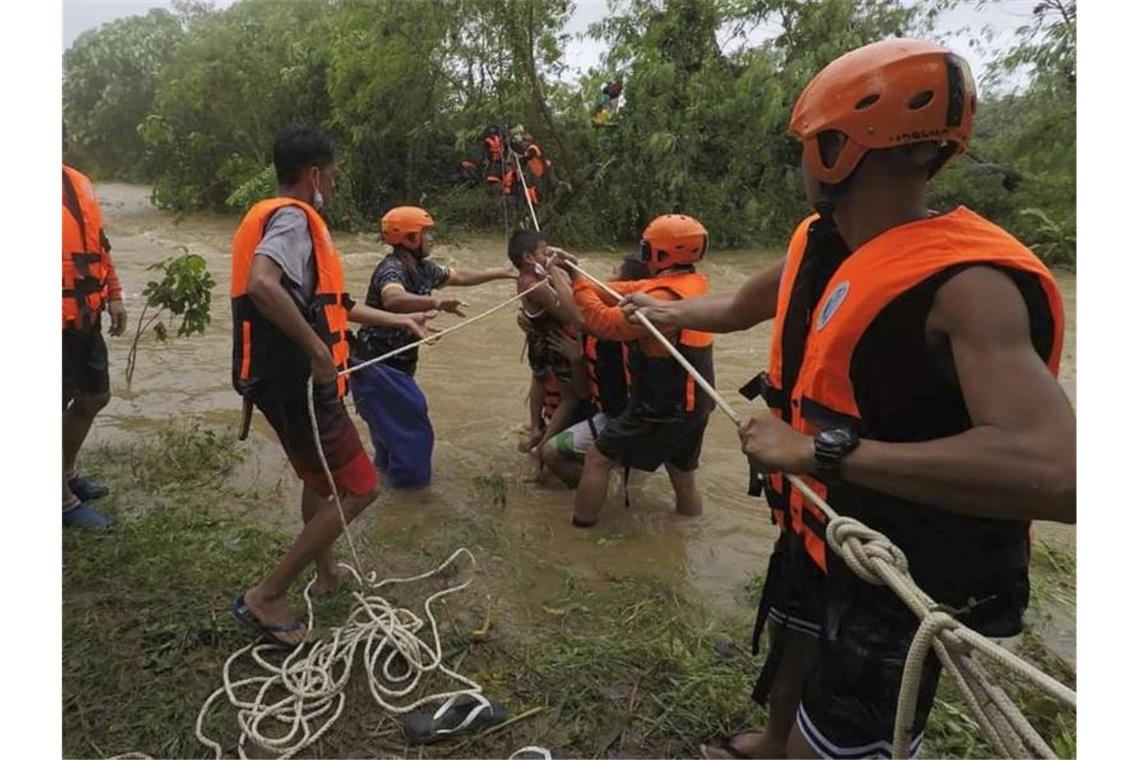 Rettungskräfte in Cagayan helfen während einer Evakuierung einem Kind. Foto: PHILIPPINE COAST GUARD/AP/dpa