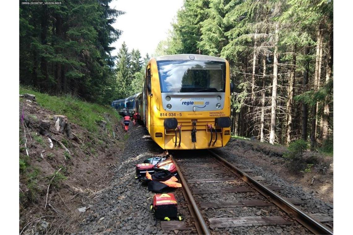 Rettungskräfte inspizieren am Unglücksort die Züge. Foto: -/Staatliche Eisenbahnverwaltung Tschechiens (SŽDC)/dpa
